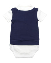 Back view of Baby White short sleeve onesie with snap buttons between the legs, short sleeves and a smart collar.  night blue mock sweater vest on top wth a snap tie at the neck shows a complete outfit that is waiting for your favorite bottoms. Soft organic cotton and a polished finished look.  